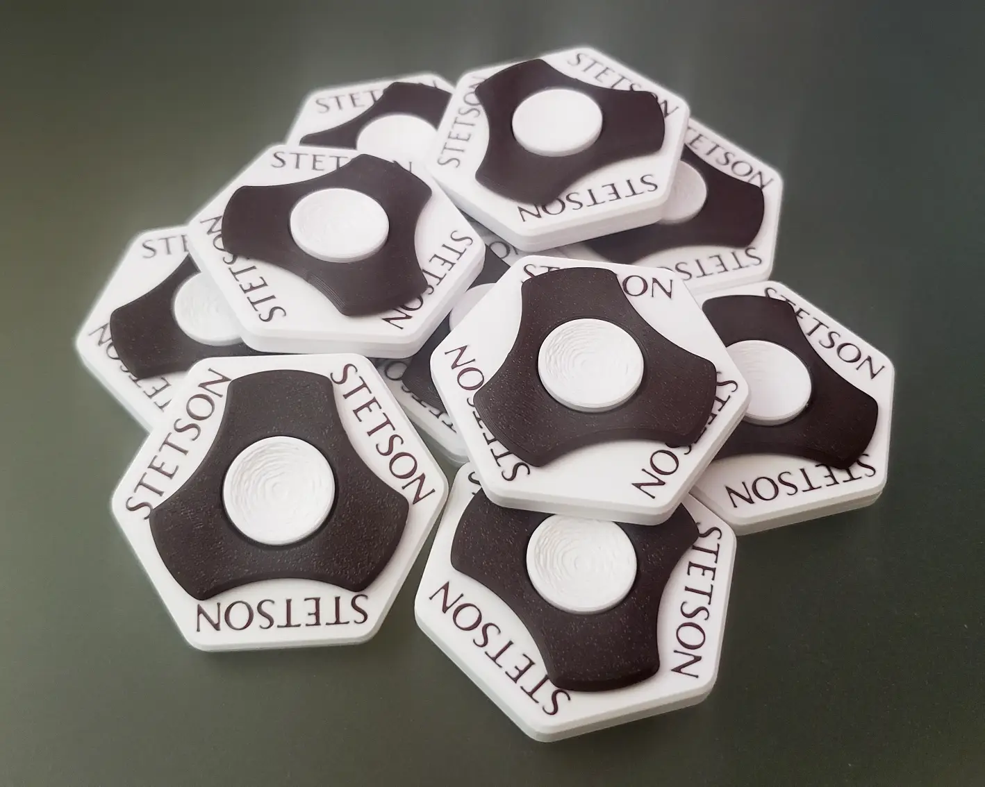 Pile of identical custom-branded Concentric Coin Spinners with Stetson branding